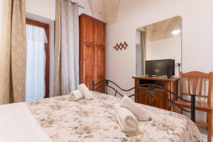 1 dormitorio con 1 cama con TV y 1 cama sidx sidx sidx sidx en Appartamento Nonna Rosa, en Ostuni 10 fotos más