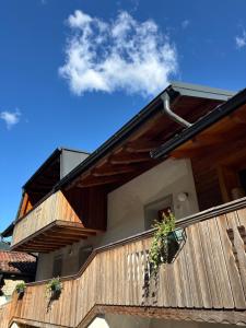 a house with wooden balconies and a blue sky at Da Zenz in Paluzza
