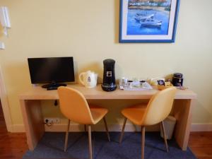 a desk with two chairs and a computer on it at Chambres 1 a 4 personnes CAPRICES ENSOLEILLES 300 m plage avec vue 2 chambres in Mers-les-Bains