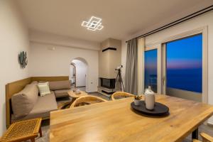 a living room with a table and a couch at Aronia Glow Villa in Imerovigli