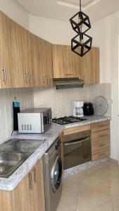 a kitchen with a microwave and a stove top oven at Appartement Moderne in Kenitra