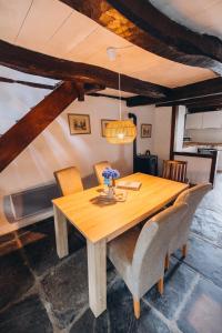 a wooden dining room table with chairs and aendant light at Lodge Kervoazec - Château de Kervoazec in Saint-Goazec