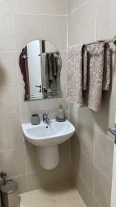 a bathroom with a sink and a mirror and towels at Appartement Moderne in Kenitra