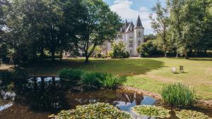 an old castle with a pond in front of it at Lodge Kervoazec - Château de Kervoazec in Saint-Goazec