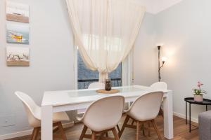 a white dining room with a white table and chairs at 15 minuti dalla stazione Principe in Genova +13 photos