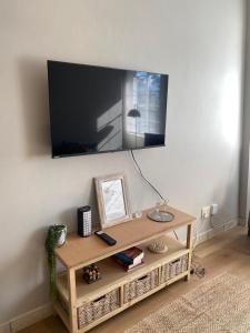 a flat screen tv on a wall with a table at Melk Tert - Paarl - Self Catering Apartment in Paarl