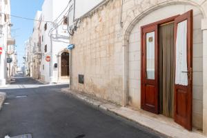 un callejón con una puerta marrón en el lateral de un edificio en Appartamento Il Barco, en Ostuni