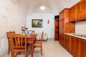 Una cocina con una mesa y sillas en una cocina. en Appartamento Il Barco, en Ostuni 6 fotos más
