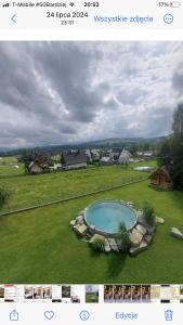 a picture of a swimming pool in a field at Chata Pod Grapom in Czarna Góra