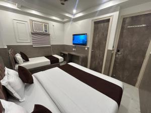 ニューデリーにあるHotel Sapphire International By ASR Hospitalityのベッド2台とテレビのある寝室 +18枚の写真