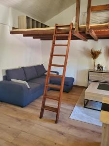 a living room with a loft bed and a blue couch at Appartement entier - cosy et lumineux - Plein centre-ville in Épinal