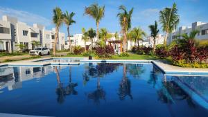 a swimming pool with palm trees and buildings at Casa 3 recamaras con alberca compartida Acapulco diamante in General Juan N Alvarez International Airport +20 photos