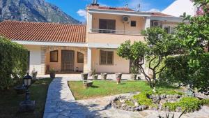 a house with a garden in front of a mountain at Villa La Cost in Donji Morinj