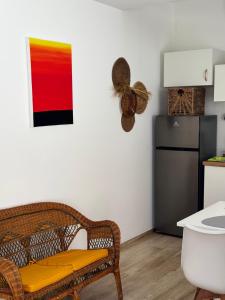 a kitchen with a wicker chair and a refrigerator at Pozzallo sea house in Pozzallo +6 photos