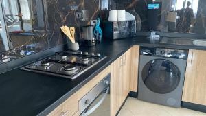 a kitchen with a stove and a washing machine at Appartement Moderne Vert in Kenitra