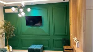 a green wall with a tv on top of it at Appartement Moderne Vert in Kenitra