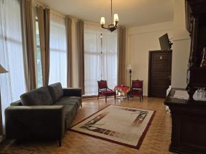 a living room with a couch and chairs and windows at Vila Cristalfrost in Poiana Brasov