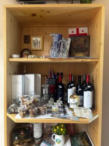 a shelf filled with bottles of wine and other items at Hotel Svanseti in Mestia