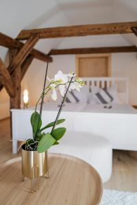 a vase with white flowers sitting on a table at Kaple Jinak in Vrchovany