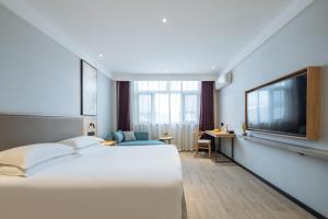um quarto de hotel com uma cama e uma TV de tela plana em Parker Hotel Huangshan Tunxi Old Street Branch em Montanhas Huangshan