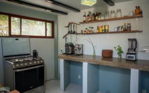 a kitchen with a stove and a counter top at Four Trees Jungle Lodge in San Juan del Sur