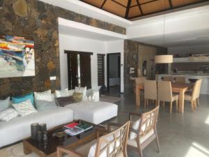 a living room with a couch and a dining room at Villa RayHan in Grand-Baie