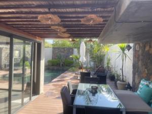 a patio with a table and chairs and a pool at Villa RayHan in Grand-Baie