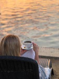 a child sitting in a chair holding a cup of coffee at Шале Рутенія - Chalet Rutenia apartments in Neporotovo