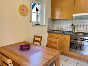 a kitchen with a wooden table and a clock on the wall at Seebrise 25 in Funfseen