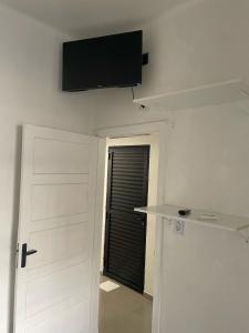 a room with a door and a flat screen tv on the wall at SUITE Metro SPExpo Airport CPB in Sao Paulo