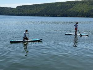 two people on paddle boards on a lake at Шале Рутенія - Chalet Rutenia apartments in Neporotovo
