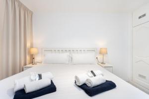 1 dormitorio blanco con 1 cama blanca grande y 2 toallas en Eden Rentals Casa Salitre Neptuno Playa la Arena, en Puerto de Santiago 45 fotos más