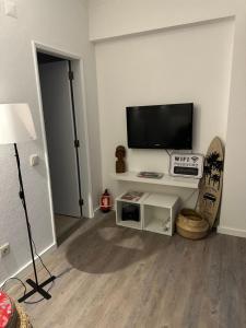 a living room with a flat screen tv on a wall at Costa da caparica in Costa da Caparica