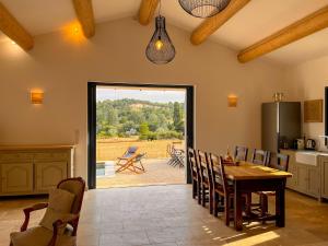 a kitchen with a table and chairs and a patio at Radegonde - Maison de charme avec piscine in Rustrel