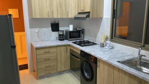 a kitchen with a stove top oven next to a sink at Appartement Orientale in Kenitra
