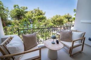 a balcony with two chairs and a table at East Blue Luxury Apartment in Kamári