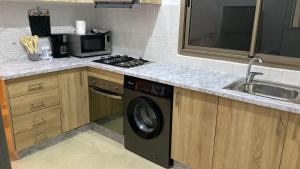 a kitchen with a sink and a washing machine at Appartement Orientale in Kenitra