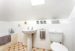 a white bathroom with a toilet and a sink at Bay View in Port Isaac +34 photos
