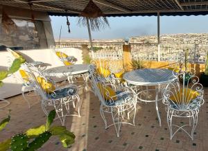 a patio with tables and chairs on a balcony at Palais AL Firdaous in Fès