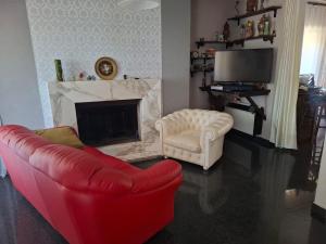 a living room with a red couch and a fireplace at La Casa di Piero in SantʼAngelo