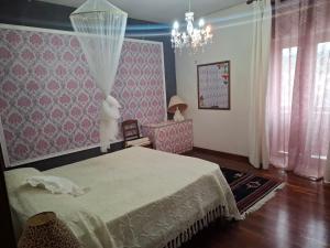 a bedroom with a bed and a chandelier at La Casa di Piero in SantʼAngelo