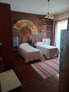 a bedroom with two beds and a painting on the wall at La Casa di Piero in SantʼAngelo