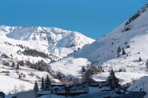 a snow covered mountain with a town in the foreground at Barèges T2 Rando Cure in Barèges