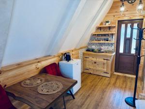 a small kitchen with a table and a refrigerator at Vekova koliba in Žabljak