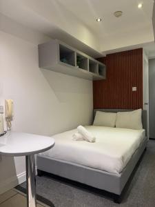 a bedroom with a white bed and a table at Central Studios Near Hyde Park in London