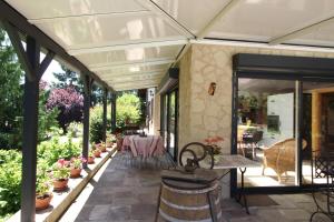 a conservatory with a table and chairs on a patio at Au Domaine Paisible - Appartement de charme avec piscine au cœur des Vosges in Hadol