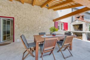 a wooden table and chairs in a patio with a fireplace at Villa Ortensija in Sveti Petar u Šumi