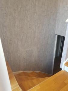 a room with a gray wall and a wooden floor at ossama in Åstorp