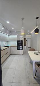 a large kitchen with white cabinets and a white table at PREMIUM apartments ЖК Автограф, Институт сердца, МВЦ, Центр серця, Братиславская, Юность, Черниговская, Левобережная, Дарница in Kyiv +27 photos