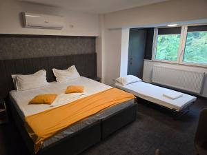 Un dormitorio con una cama grande con dos almohadas. en Corso Apartments B&B, en Focşani
